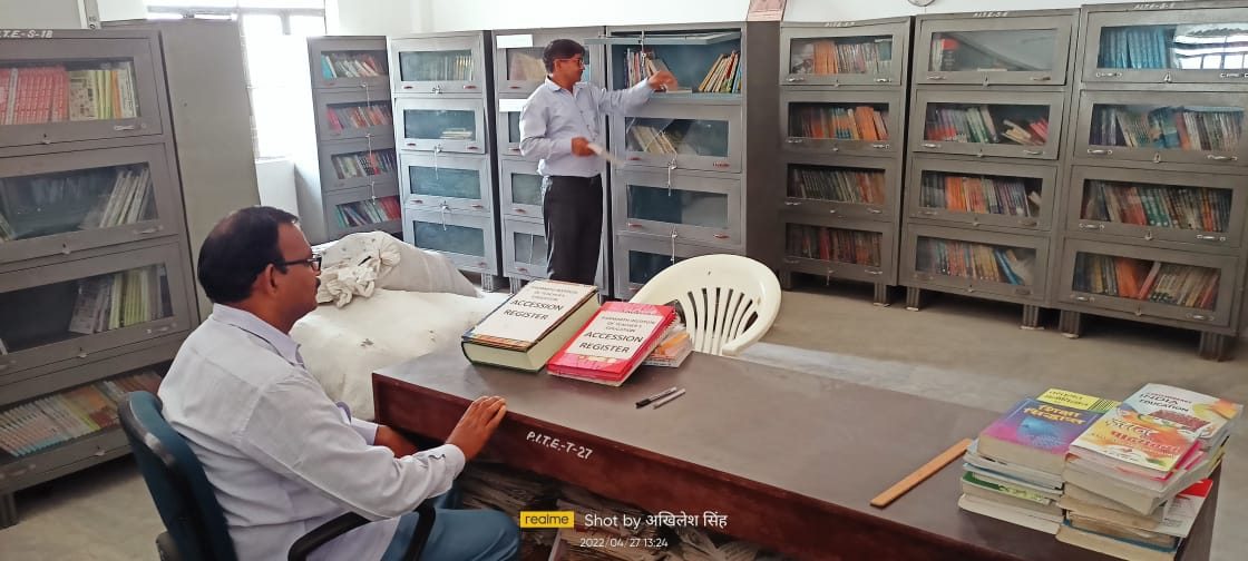 Library at Parmarth Institute with a staff member at the issue desk and book cupboards